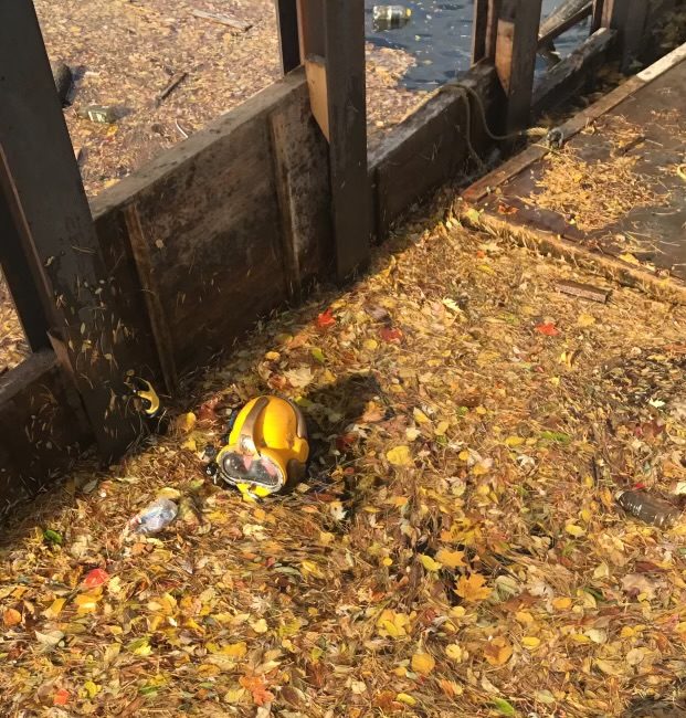 Commercial Diver in water swimming through debris.